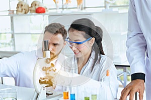 Group of scientist working putting medical chemicals sample in test tube at laboratory together