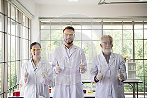 Group of scientists people standing and showing thumb up together in laboratory,Successful teamwork and reserch working photo