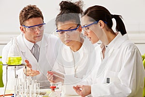 Group Of Scientists Performing Experiment In Laboratory