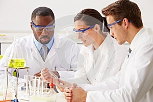 Group Of Scientists Performing Experiment In Laboratory