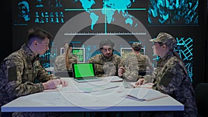 Group of security squad in control center. Military headquarters surveillance officers working in office on laptop with