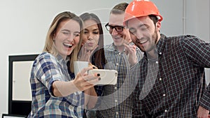 Group selfie shot of colleagues having fun in their office