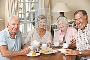 Group Of Senior Couples Enjoying Afternoon Tea Together At Home