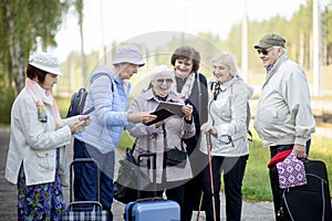 Group of  senior elderly people looking at digital map on traveling journey during pandemic.COVID-19 travel in the New Nor