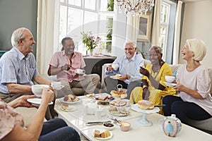 Group Of Senior Friends Enjoying Afternoon Tea At Home Together