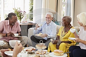 Group Of Senior Friends Enjoying Afternoon Tea At Home Together