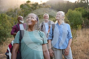 Group Of Senior Friends Enjoying Hiking Through Countryside Together