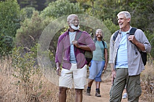 Group Of Senior Friends Enjoying Hiking Through Countryside Together