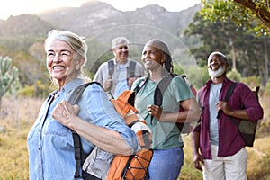 Group Of Senior Friends Enjoying Hiking Through Countryside Together