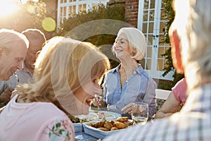 Group Of Senior Friends Enjoying Outdoor Dinner Party At Home