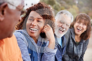 Group Of Senior Friends On Hike In Countryside Talking And Laughing Together photo