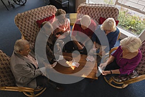 Group of senior friends playing cards at nursing home