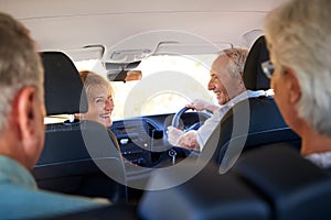 Group Of Senior Friends Sitting In Car Driving To Vacation