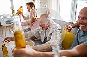 Group of senior friends watching movie indoors, party, social gathering and having fun concept.