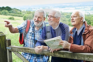 Group Of Senior Male Friends Hiking In Countryside