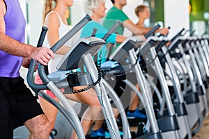 Group with senior people on elliptical trainer in gym