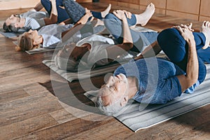 group of senior people stretching in yoga mats