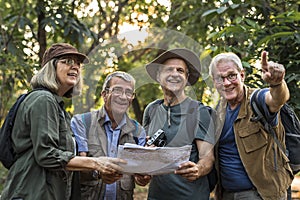 Group of senior trekkers checking a map for direction