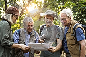 Group of senior trekkers checking a map for direction