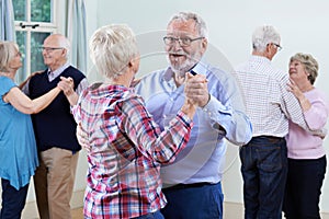 Group Of Seniors Enjoying Dancing Club Together