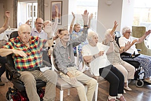 Group Of Seniors Enjoying Fitness Class In Retirement Home