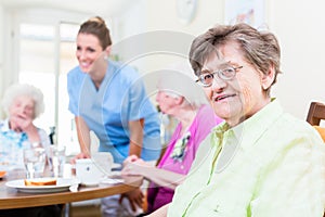 Group of seniors having food in nursing home