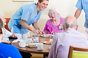 Group of seniors having food in nursing home