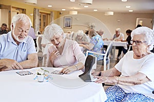 Group Of Seniors Playing Game Of Bingo In Retirement Home