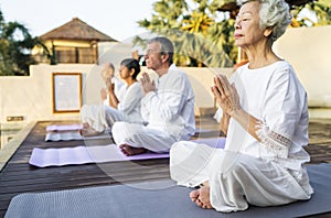 Group of seniors practicing yoga in the morning photo