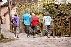 Group of seniors running outdoors in the old town.