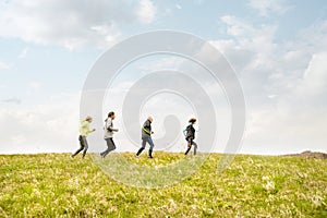 Group of seniors running outside on the green hills.