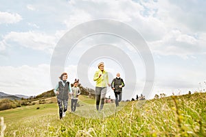 Group of seniors running outside on green hills.
