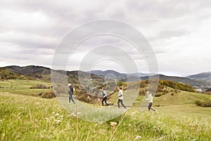 Group of seniors running outside on the green hills.