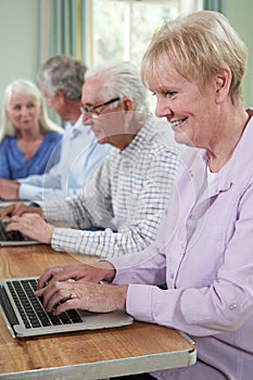 Senior Woman With Tutor In Computer Class