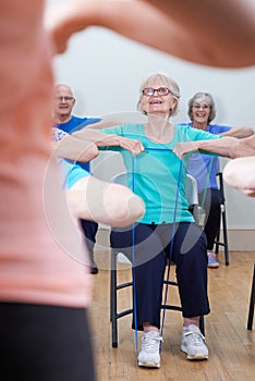 Group Of Seniors Using Resistance Bands In Fitness Class