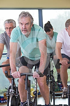 Group of seniors using spinning bikes photo