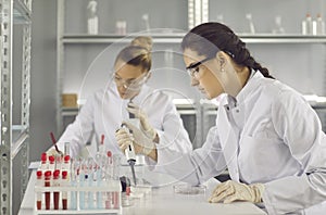 Group of serious female scientists working in a pharma or biotech science laboratory