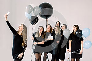 Group of seven girls best friends making selfie on smartphone, enjoying birthday party with cake and air balloons