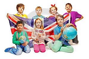 Group of seven kids studying geography with globes