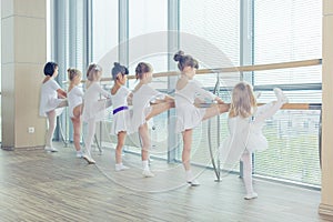 Group of seven little ballerinas standing in row and practicing