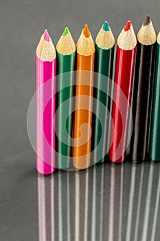 Group of sharp colored pencils with reflexions