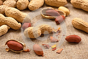 Group of shelled and unshelled nuts on burlap. Food peanut closeup