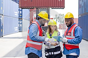 Group of shipment worker dressed in hardhat, safety vest and protective glove working during the day under sunlight. There are