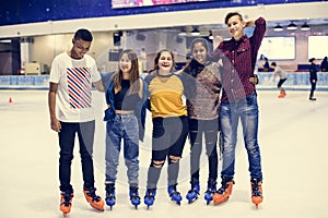 Group shot of teenage friends on the rink ice skating rink