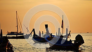 Group of silhouette long tail boat converted floating in the andaman sea with golden light of the Sun