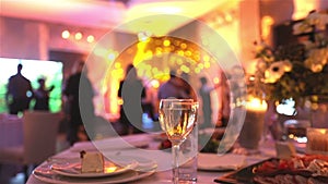 Group of silhouetted people dancing in a dark banquet hall for a wedding reception.The Wedding Banquet, people dance -