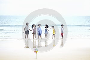 Group of six boys and girls holding hands on the beach, cute kids having fun on sandy summer beach, happy childhood friend playing