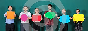 Group of six business people team standing together and holding colorful and different shapes of speech bubbles