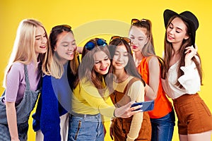 Group of six laughing girls having party summer style yellow background studio