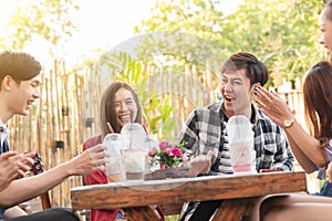 Group of six teenagers having fun together in coffee shop on the